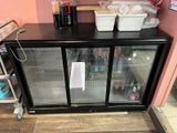 a refrigerator with two glass doors and a shelf with drinks