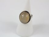 silver ring with a brown stone in the middle of it on a white napkin