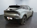 the rear end of a silver sports car parked in a showroom