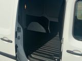 une camionnette blanche dont la portière est ouverte dans un parking