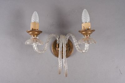 une paire d'appliques en cristal et en laiton sur un mur blanc
