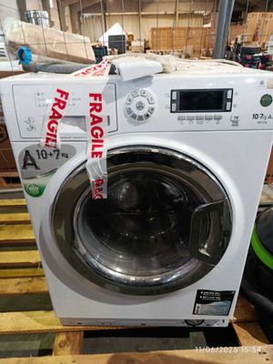 a white washing machine sitting on top of a wooden pallet