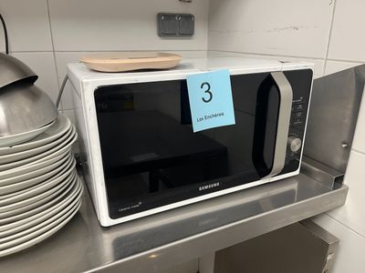 a microwave that is sitting on a shelf in a kitchen