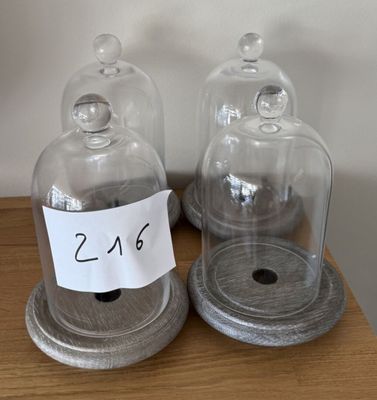 deux cloches posées sur une table en bois, sur lesquelles est accrochée une pancarte