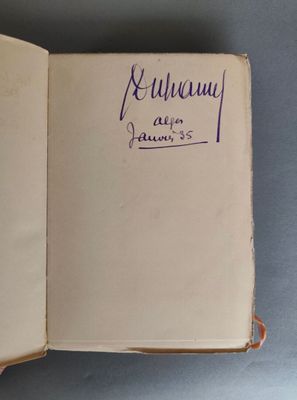 un livre ouvert avec une écriture dessus, posé sur une table