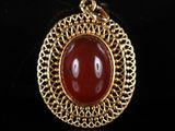 un pendentif en or et en cornaline sur fond noir