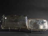 two silver trays sitting on a metal stand