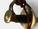 a close up of a sword with a red rope on it