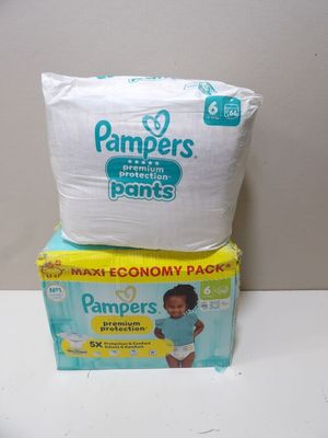 two boxes of diapers sitting on top of each other on a table