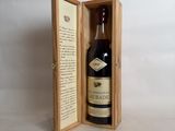an open wooden box with a bottle of liquor inside of it
