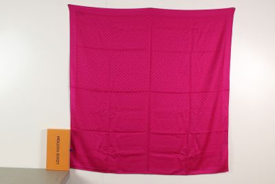 a pink blanket hanging on a wall next to a chair