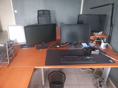 a desk with two monitors and a keyboard on it