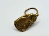 a close up of a gold keychain on a white surface