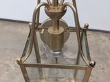 an antique brass and glass lantern with a brass handle