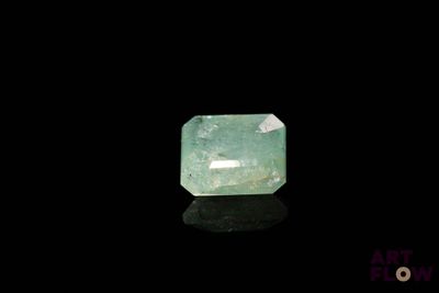 un gros plan d'une émeraude verte sur une surface noire