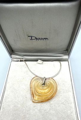 une photo d'un pendentif jaune en forme de cœur dans un écrin en argent