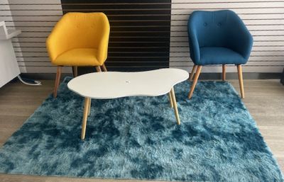 two chairs and a table on a rug in a room