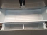underside view of a stainless steel refrigerator with its door open
