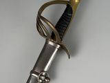 a close up of a sword with a gold handle on a white surface