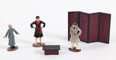 three figurines of people standing next to each other