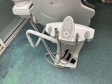a toilet with a seat that is attached to the side of it
