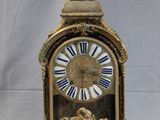 a gold clock with blue and white roman numerals on it