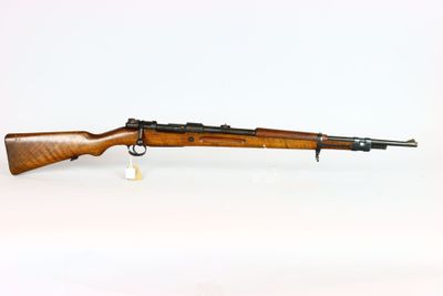 a rifle on a white surface with a white background
