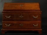 an old wooden chest of drawers with brass handles on a black background