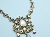 a close up of a necklace on a table with a white background