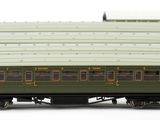 four green train cars that are lined up on a white surface