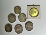 six different coins sitting next to each other on a white surface