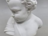 white marble bust of a young boy with curly hair and a blue base