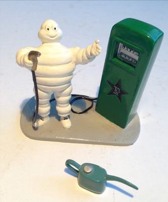 figurine représentant un homme avec une pompe à essence, à côté d'une pompe à essence verte