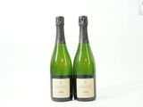 deux bouteilles de vin posées l'une à côté de l'autre sur une surface blanche