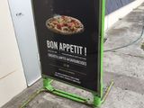a sign for a pizza restaurant on the side of the street