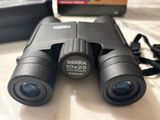 a pair of binoculars sitting on a table next to a camera