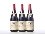 three bottles of red wine sitting on top of a white table