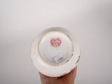 a person holding a white plate with a red heart on it