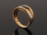 a close up of a gold ring with diamonds on a black surface
