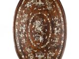 une assiette ovale en bois ornée d'un motif floral