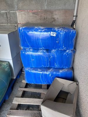 a stack of blue plastic containers sitting on a pallet