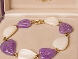 purple and white leaf bracelet in a box with a gold clasp