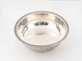 a silver bowl on a white surface with a white background