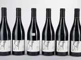 six bouteilles de vin rouge sont alignées