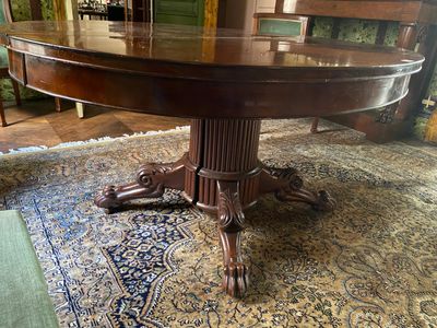 a large wooden table on a rug in a living room