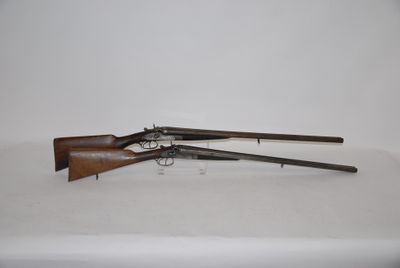 a pair of guns on a table with a white background