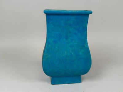 a blue vase that is sitting on a white surface