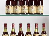 several bottles of wine are lined up on a glass shelf