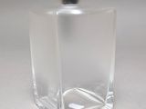 a clear glass bottle with a black flower in it