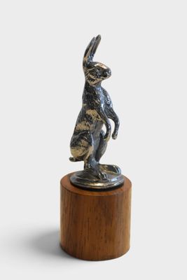 an image of a statue of a rabbit on a wooden pedestal